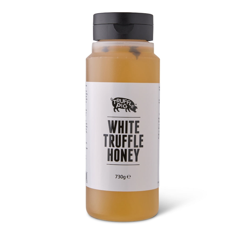 A clear plastic bottle of Truffle Pig White Truffle Honey with a black cap and a white label, set against a plain white background.