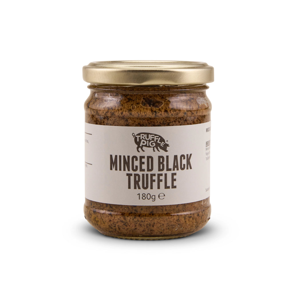 A glass jar of Truffle Pig's Minced Black Truffle 180g with a gold lid and a beige label, set against a plain white background.