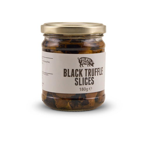 A glass jar of Truffle Pig's Black Truffle slices 180g with a gold lid and a beige label, set against a plain white background.