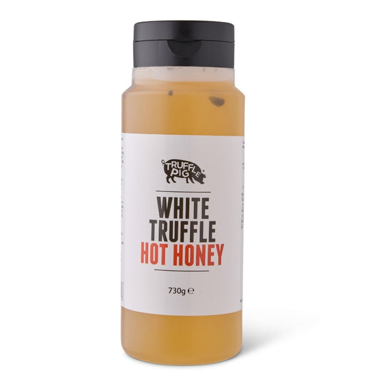 A bottle of Truffle Pig White Truffle Hot Honey, honey inside a clear plastic bottle with a black cap and a white label.